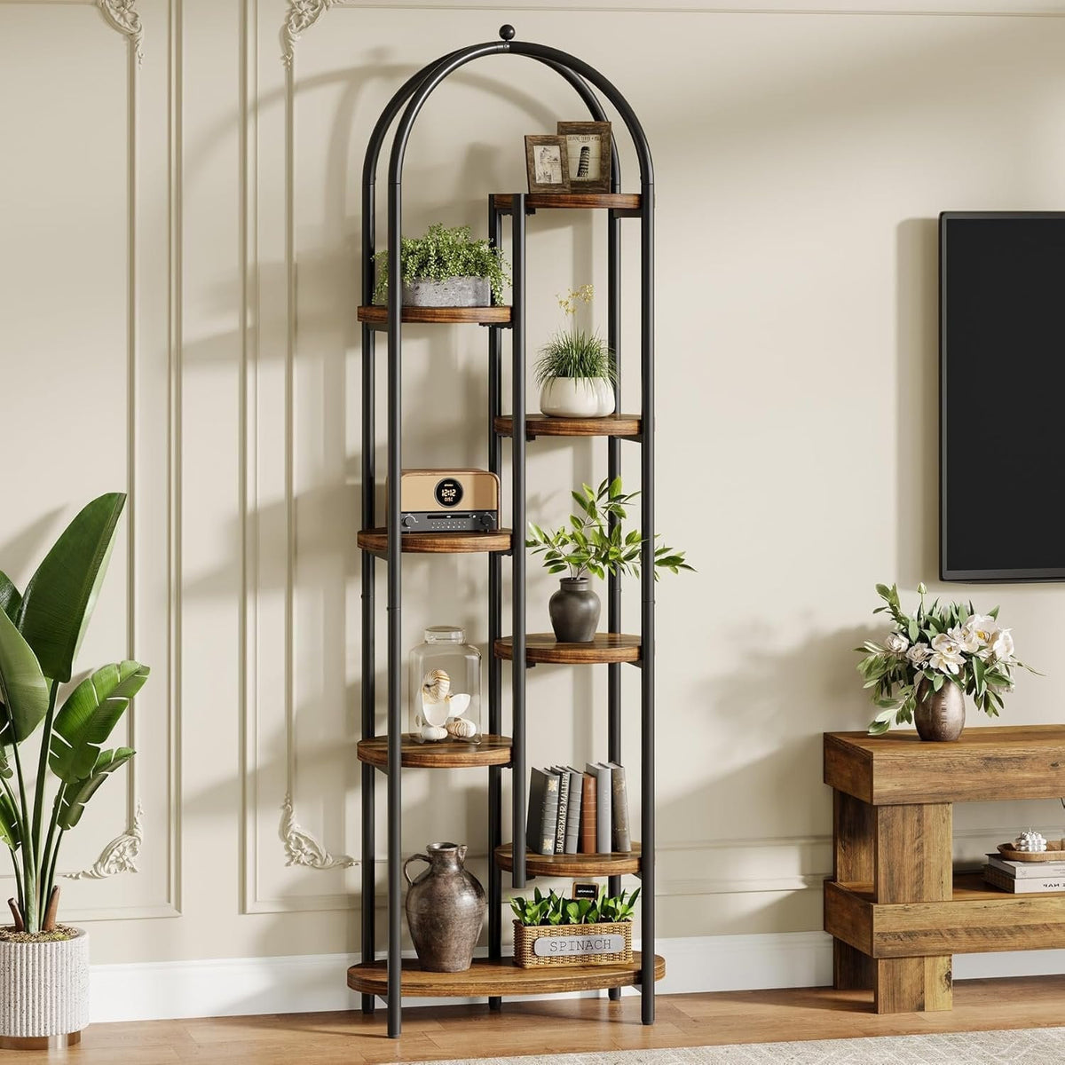 Plant arch beside a TV wall styled with plants and books