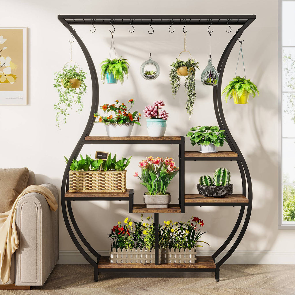 Vase shaped plant display beside a sofa holding tulips and succulents