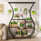 Vase shaped plant display beside a sofa holding tulips and succulents