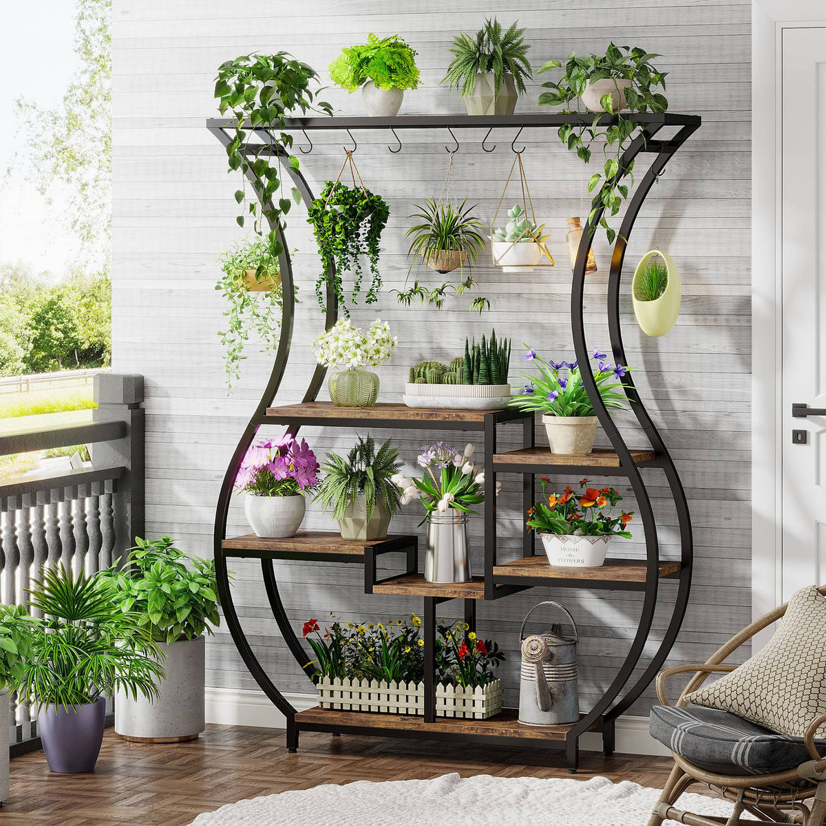 Vase shaped plant stand on a porch holding trailing and potted plants