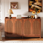 Brown walnut buffet styled with a lamp and sunflowers against a gallery wall