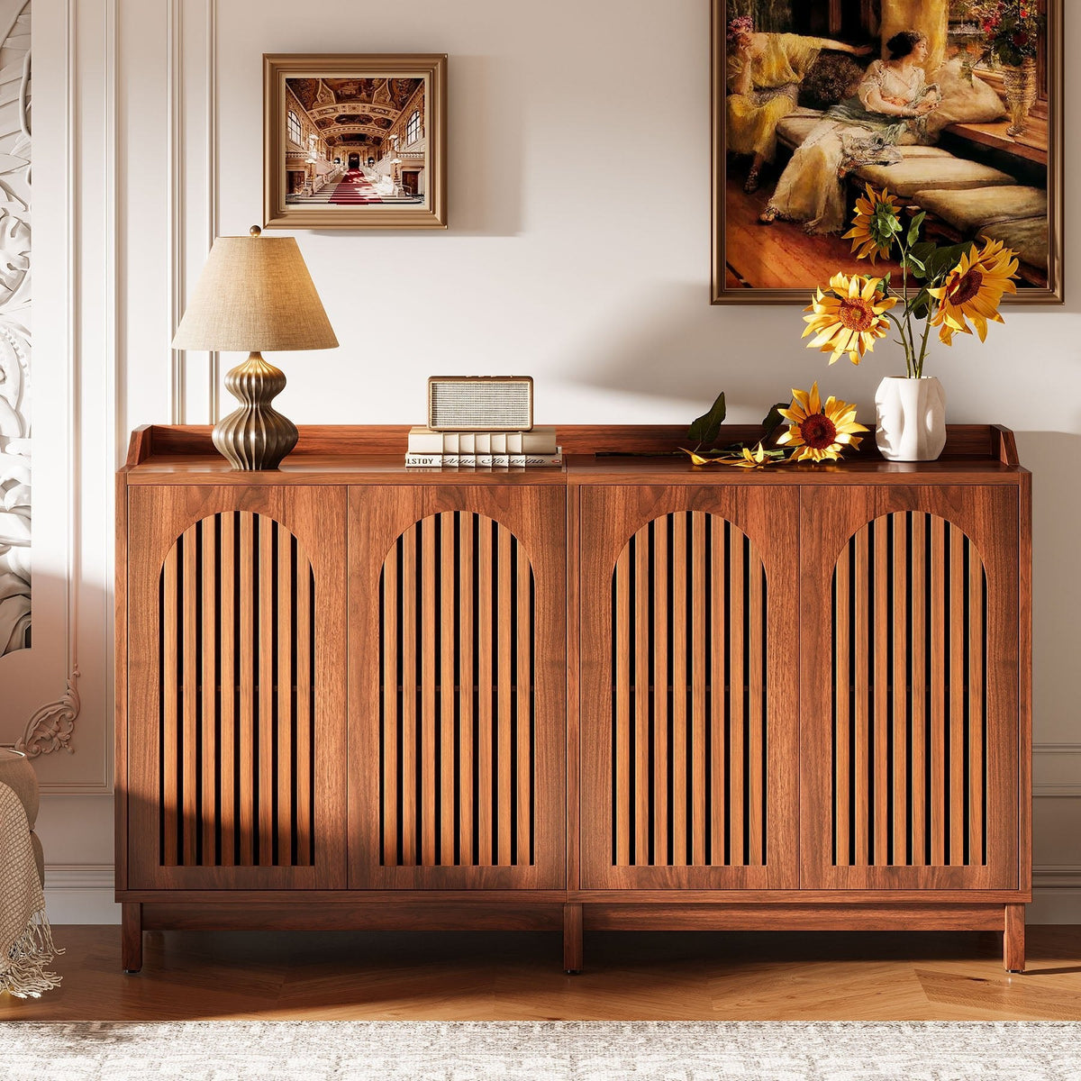 Brown walnut buffet styled with a lamp and sunflowers against a gallery wall