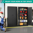 Black storage cabinet standing open in a garage holding power tools, paint tins and parts bins while a mechanic works alongside