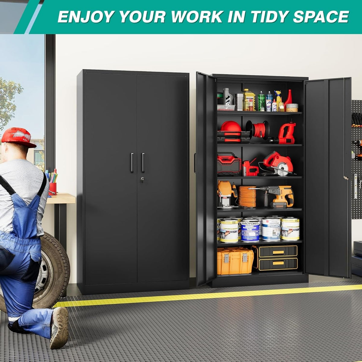 Black storage cabinet standing open in a garage holding power tools, paint tins and parts bins while a mechanic works alongside