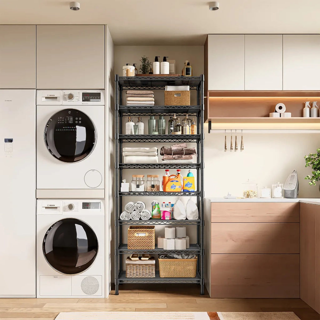 Slim black wire rack in a laundry room beside a stacked washer and dryer, holding bottles and folded linens