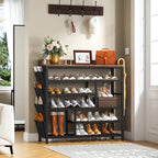 Six tier shoe rack with a wood top standing in a bright hallway holding shoes, boots and a bag, with coat hooks above
