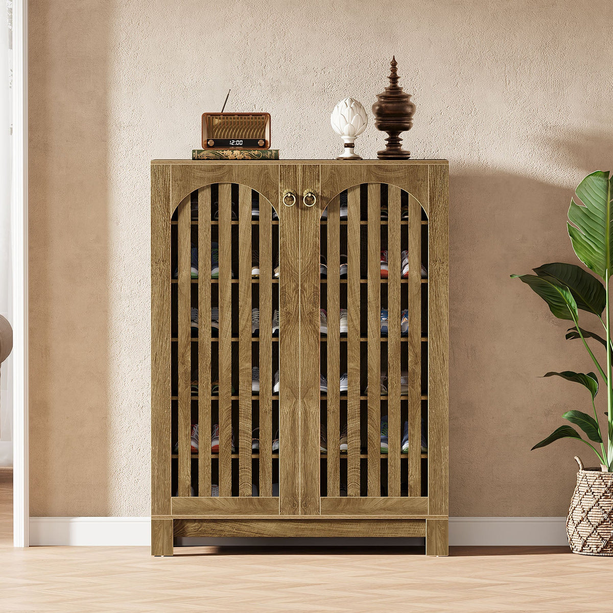 Oak tone shoe cabinet styled against a wall with a radio and plant