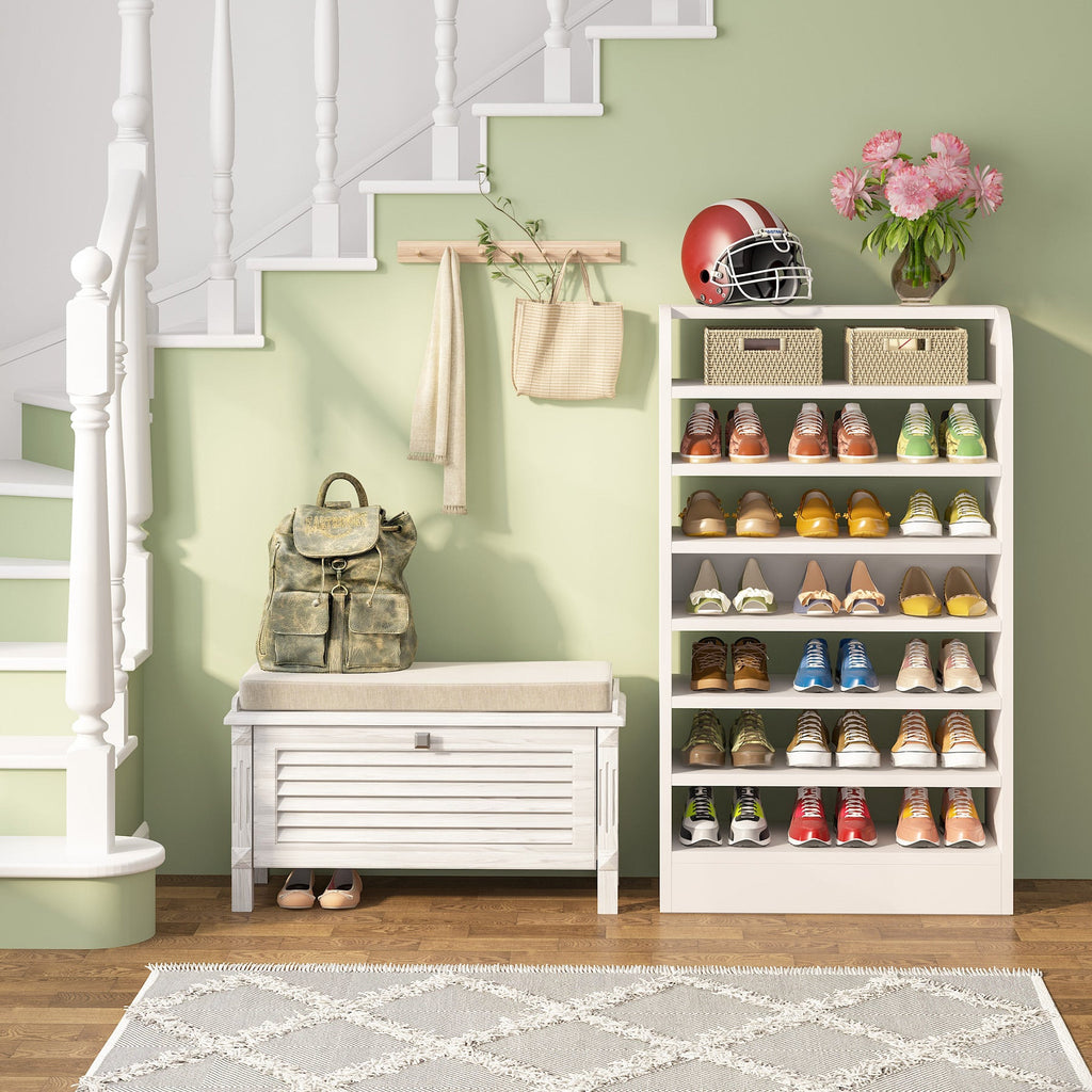White shoe shelf by a staircase with shoes and baskets on its tiers