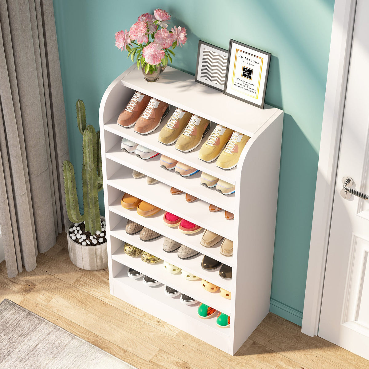 Loaded 8 tier shoe shelf in a teal entryway with framed art