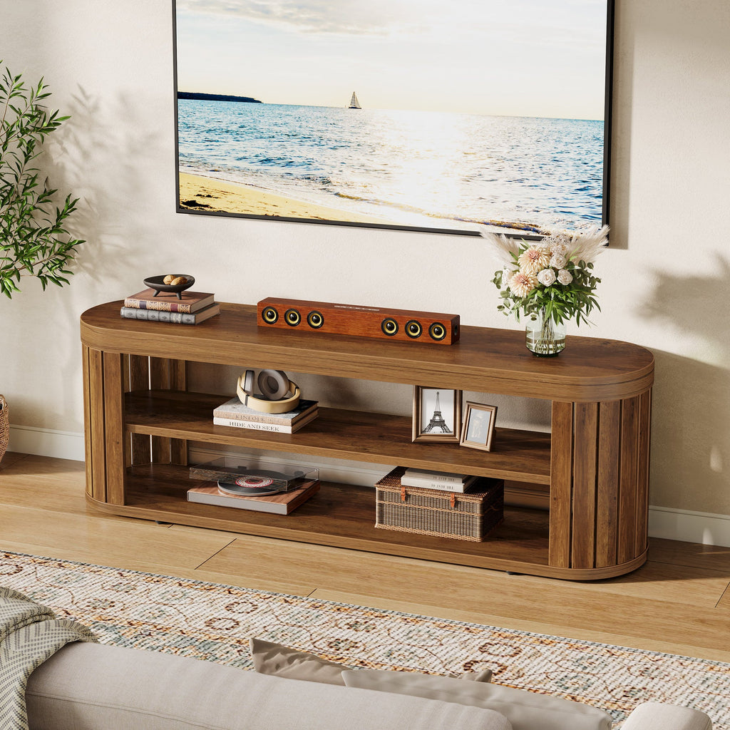 Slim oval TV stand with a soundbar and picture frames by a window