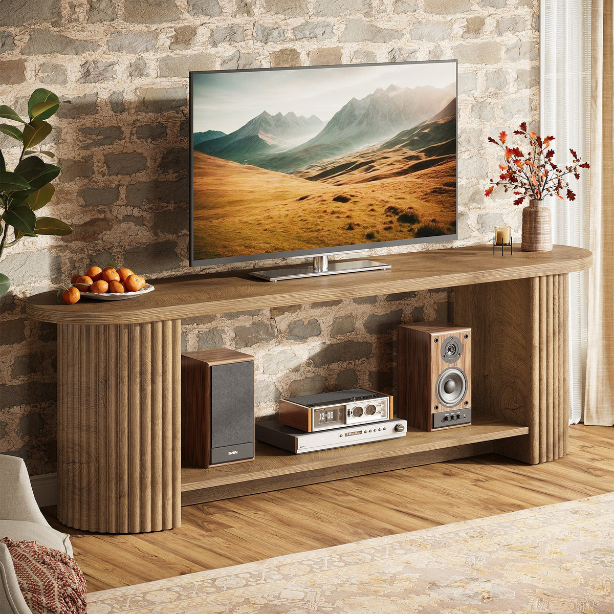 Fluted TV stand holding a TV and speakers against a brick wall