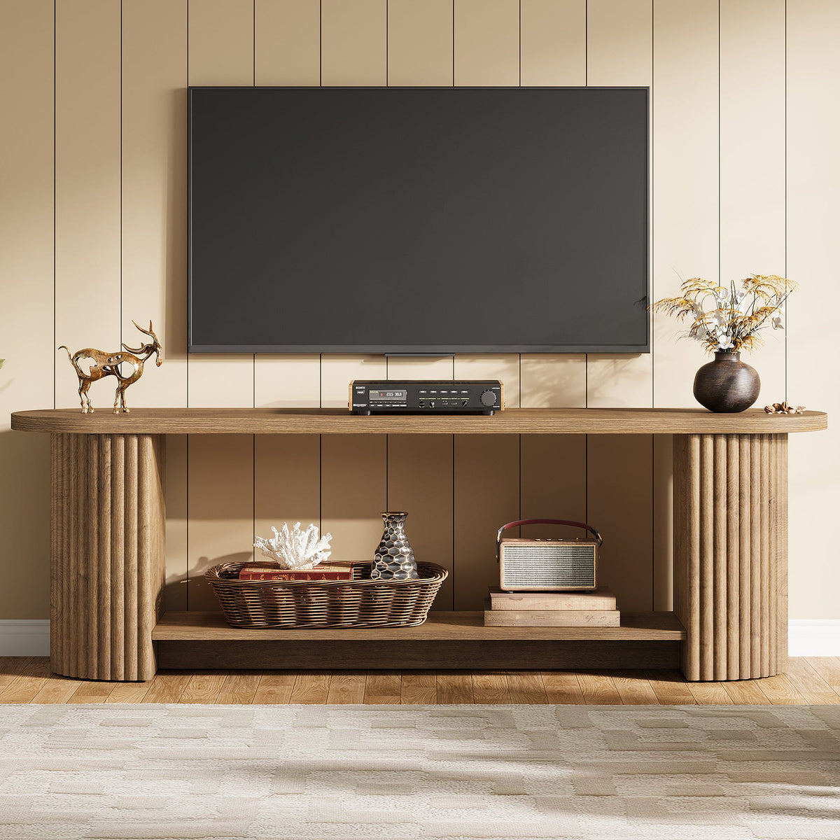 Oval fluted media console with a large TV and baskets on the shelf