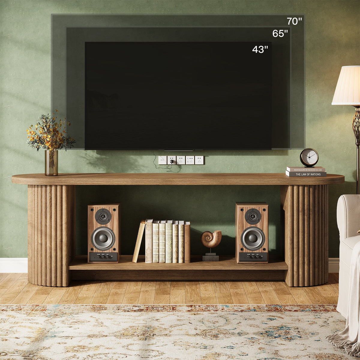 Fluted TV stand under a wall-mounted TV with speakers and decor