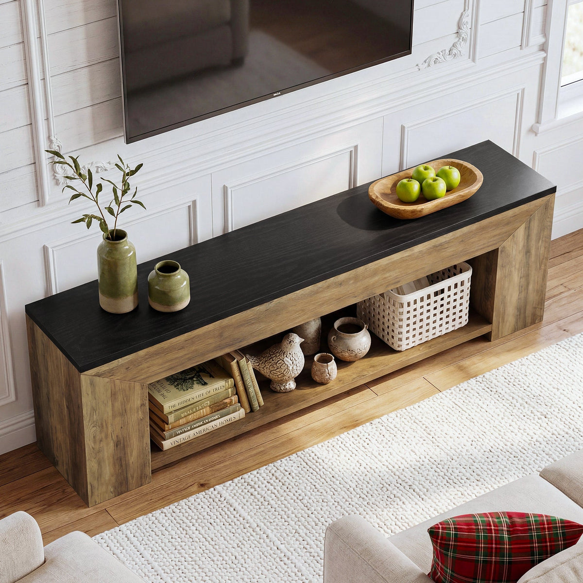 Detail view of the full-width open lower shelf with media devices and baskets