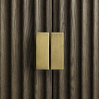 Close-up of brushed brass handles on fluted Grey Oak doors